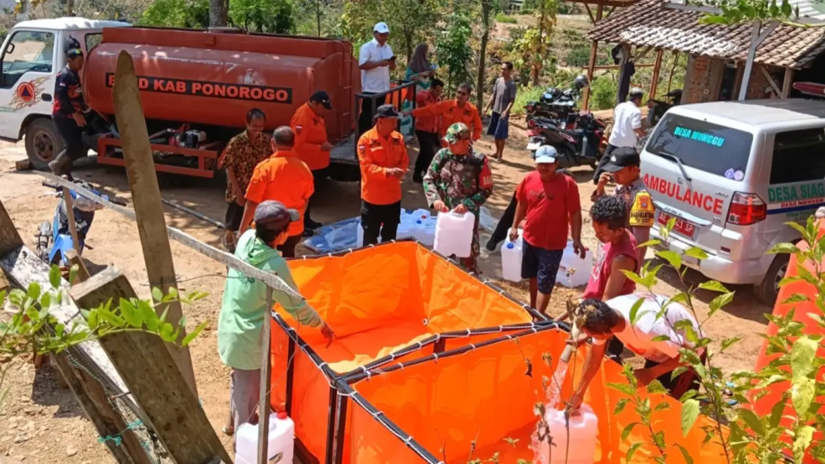 DROPPING AIR: Warga di wilayah terdampak kekeringan menerima pasokan air bersih. DOK RADAR MADIUN