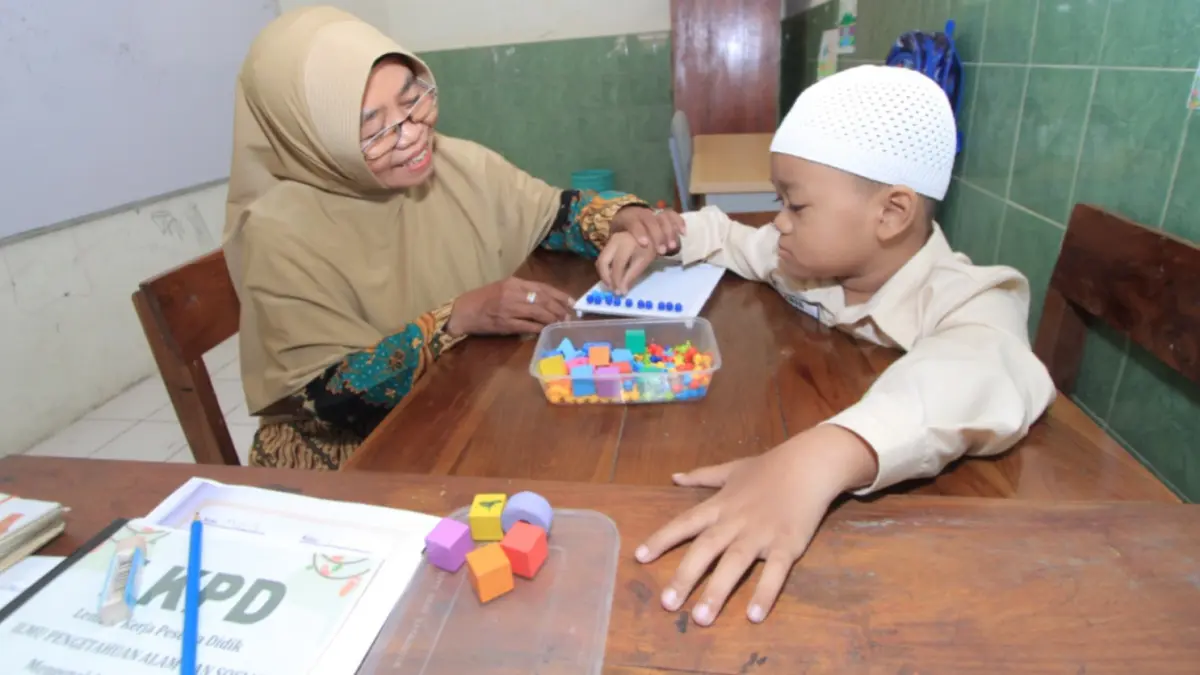 PENDAMPINGAN INDIVIDUAL: Guru SLBN Karangrejo mendampingi siswa berkebutuhan khusus secara personal melalui program KANCIL sebagai persiapan sebelum mengikuti pembelajaran klasikal. (Aji Putra/Jawa Pos Radar Magetan)