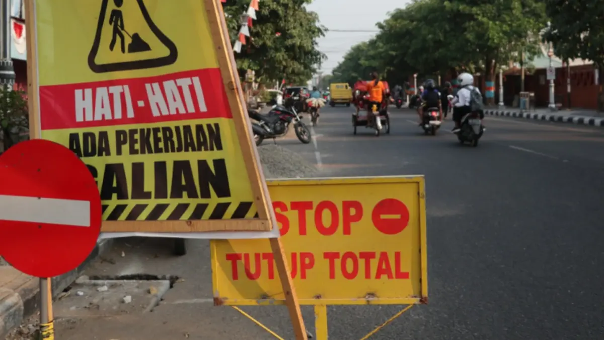 BENAHI DRAINASE: Petugas DPUPKP Ponorogo memperbaiki saluran air di sepanjang Jalan HOS Cokroaminoto. (Sugeng Dwi N./Jawa Pos Radar Ponorogo)