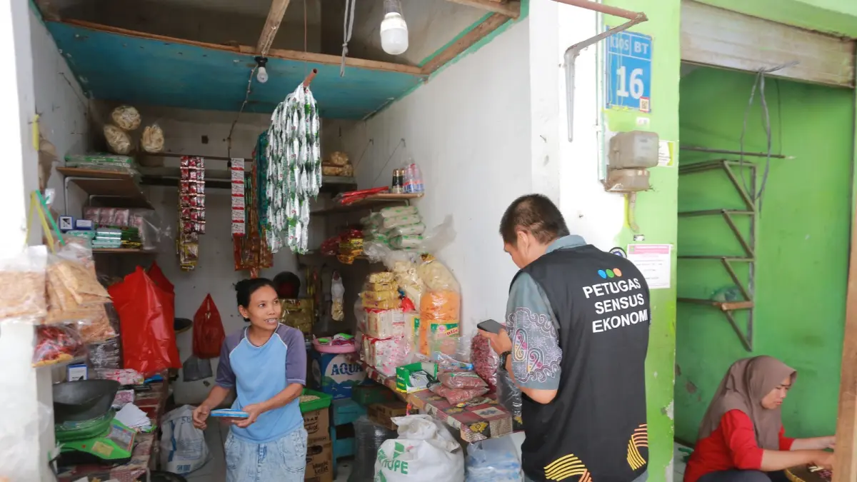 KEJAR TARGET: Petugas BPS Kota Madiun melakukan pendataan Sensus Ekonomi 2026 terhadap pedagang di Pasar Besar Madiun. (Bagas Bimantara/Jawa Pos Radar Madiun)