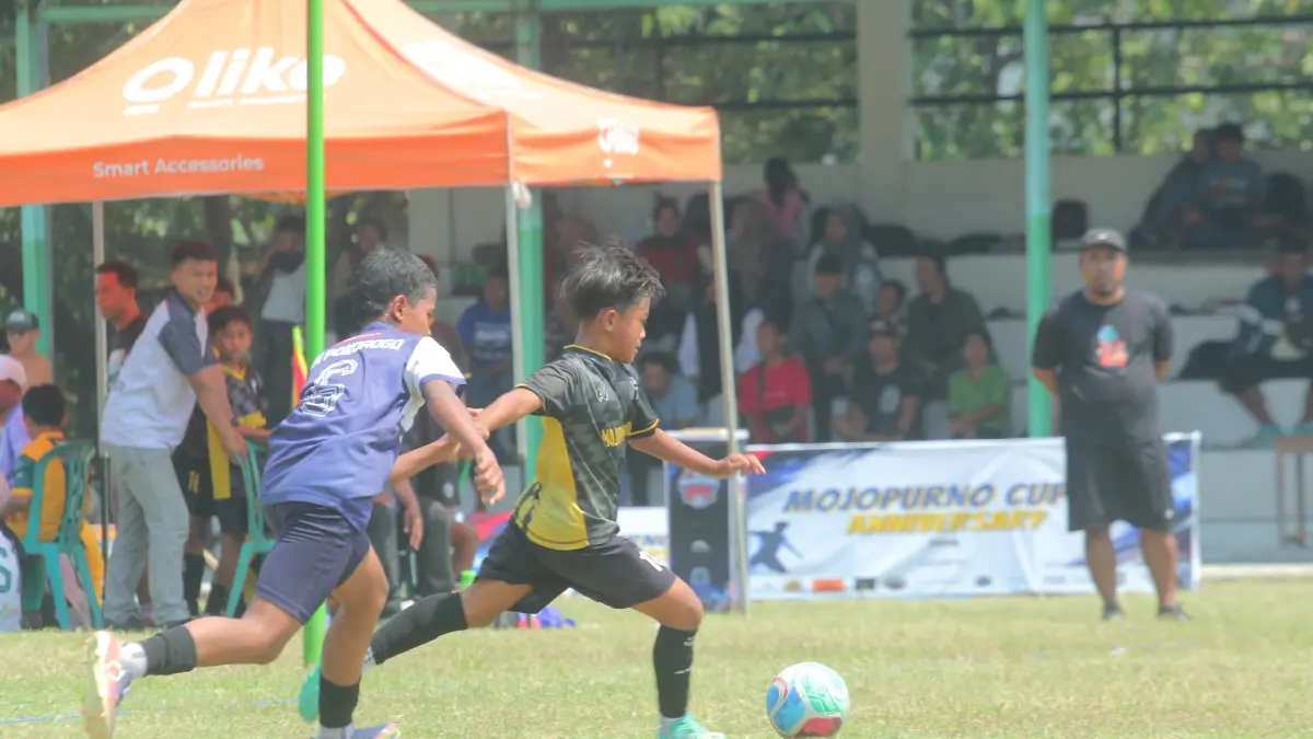 KETAT: Pesepak bola usia dini beradu kemampuan dalam Mojopurno FC Cup IV 2026 di Lapangan Desa Mojopurno, Wungu. (Erwan Marwantaka for Radar Caruban)