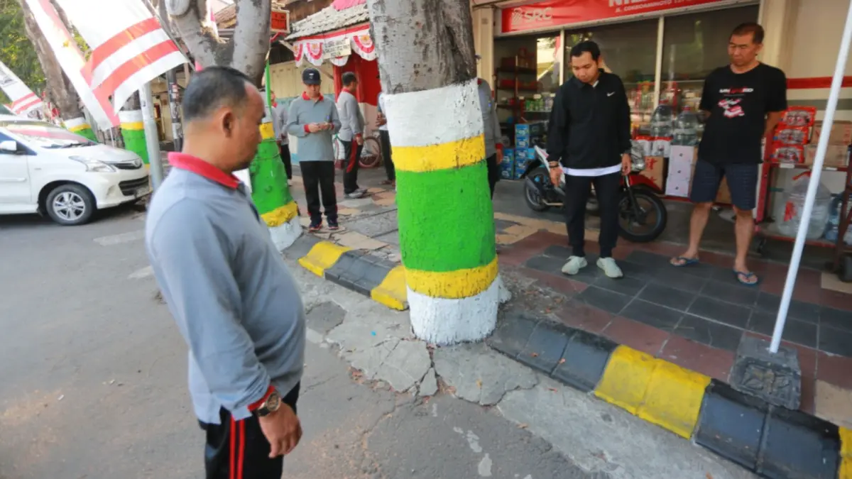 BAKAL DITATA: Plt Wali Kota Madiun F. Bagus Panuntun meninjau pepohonan tua di Jalan Cokroaminoto yang akarnya merusak trotoar dan aspal. (Bagas Bimantara/Jawa Pos Radar Madiun)
