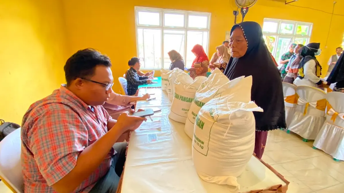 BANTUAN PANGAN: Warga Desa Balerejo, Kecamatan Kebonsari, Kabupaten Madiun, menerima bantuan pangan berupa 30 kilogram beras untuk alokasi Juli-September, Senin (10/8). DIAN RAHAYU/RADAR CARUBAN