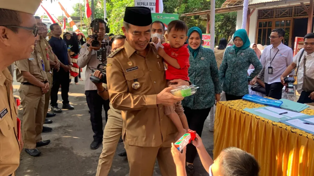 BULAN TIMBANG: Bupati Hari Wuryanto bersama ketua TP PKK Kabupaten Madiun saat menghadiri penimbangan dan pemberian makanan tambahan pada balita di Posyandu Kartini, Desa Uteran. (LODITYA/RADAR MADIUN)