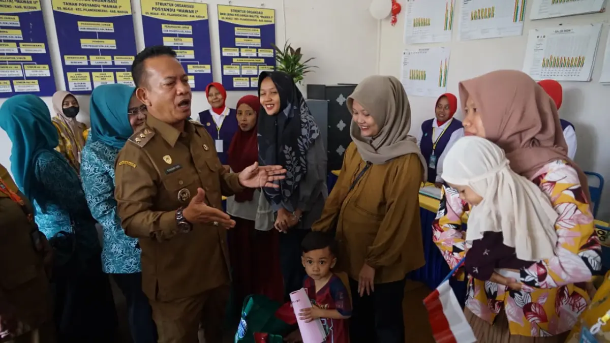 VITAMIN: Wabup dr Purnomo Hadi saat memberikan vitamin A bagi balita peserta Bulan Timbang di Posyandu Mawar di Desa Ngale. (LODITYA/RADAR MADIUN)