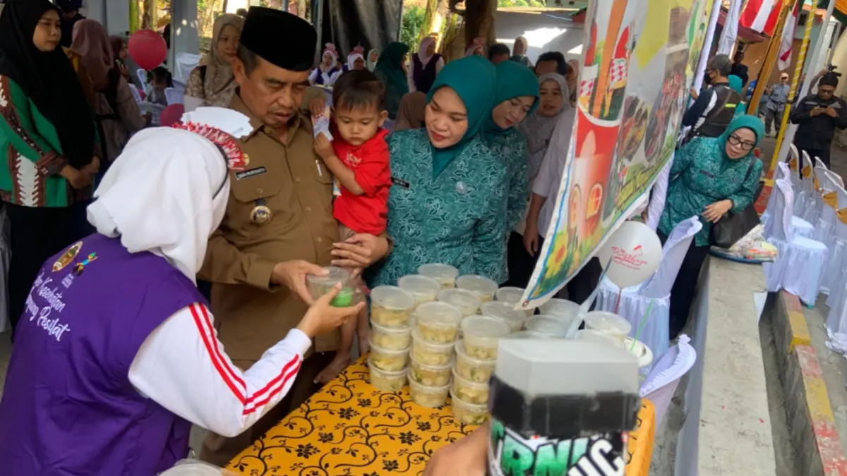 CEGAH STUNTING: Bupati Madiun Hari Wuryanto memantau penimbangan dan pemberian makanan tambahan kepada balita dalam Bulan Timbang di Posyandu Kartini, Desa Uteran.