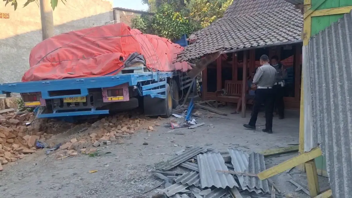 RINGSEK: Truk tronton bermuatan 32 ton semen menerjang dua rumah warga setelah bertabrakan dengan sepeda motor di Jalan Raya Ngawi–Mantingan, Desa Ngale, Paron, Rabu (12/8). (ASEP SYAEFUL BACHRI/JAWA POS RADAR NGAWI)