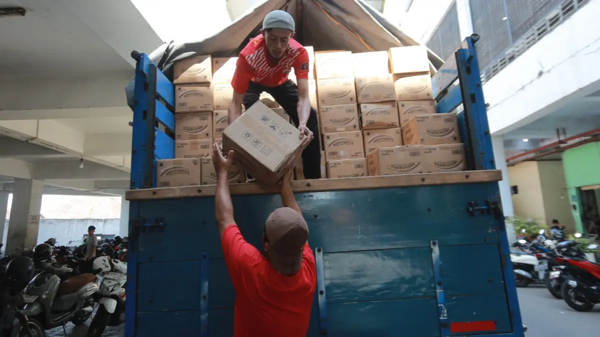 JAGA PASOKAN: Pedagang menerima distribusi MinyaKita untuk menjaga ketersediaan minyak goreng di pasar tradisional Kota Madiun, Rabu (12/8). (BAGAS BIMANTARA/JAWA POS RADAR MADIUN)