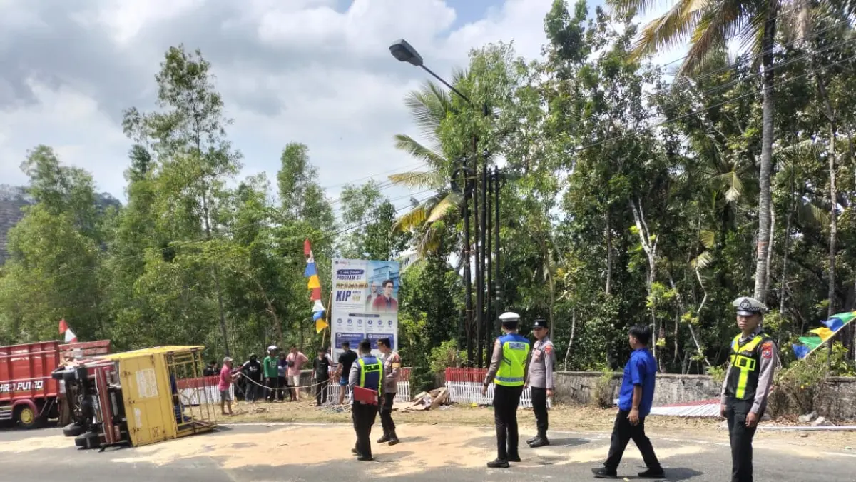 BERSERAKAN: Kardus berisi minyak goreng berhamburan setelah truk pengangkutnya terguling di turunan Sedeng, Pacitan, Sabtu (15/8). (Jawa Pos Radar Pacitan)