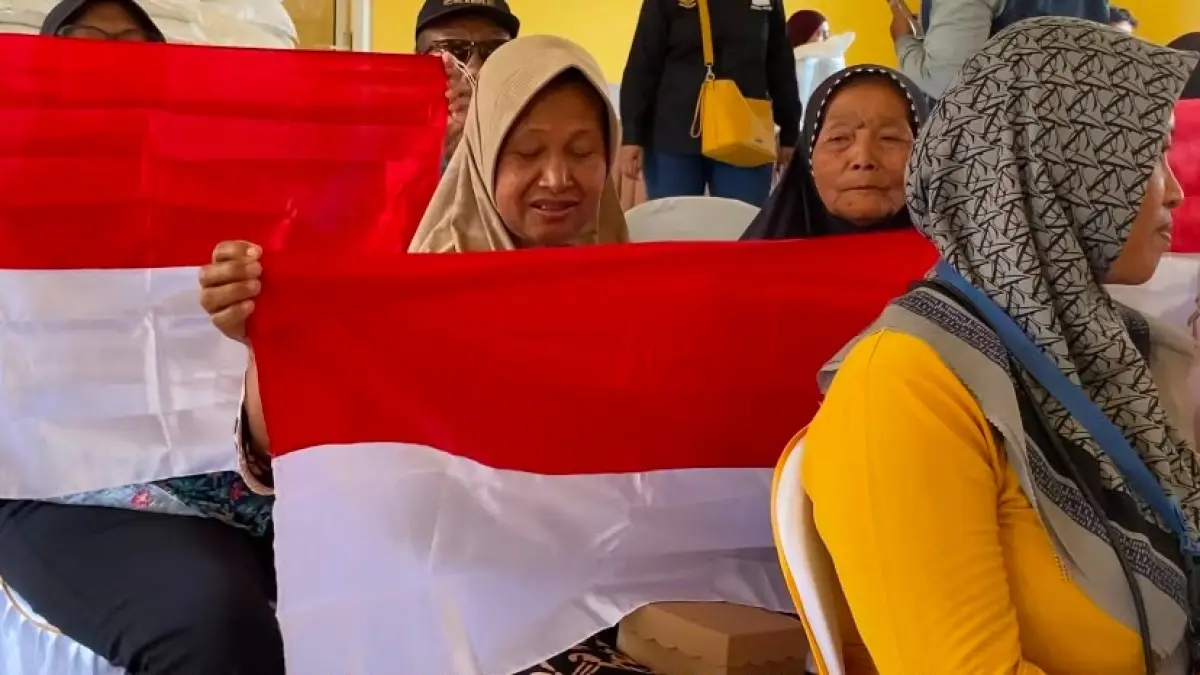 BAHAGIA: Warga Kabupaten Madiun menerima bendera Merah Putih yang dibagikan gratis Pemkab Madiun untuk menyemarakkan HUT ke-81 Kemerdekaan RI.