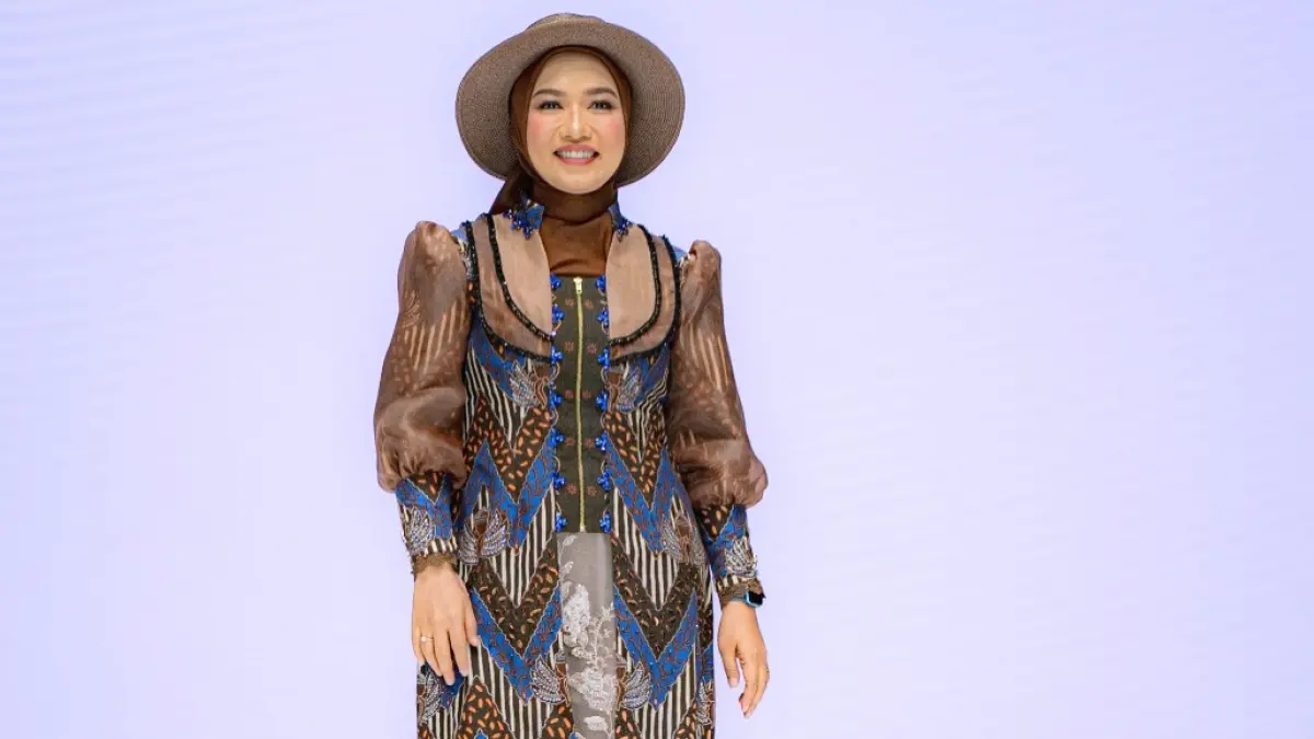 MENAWAN: Ketua Dekranasda Ngawi Ana Mursyida memperagakan busana karya desainer Ngawi dalam Jogja Fashion Week 2026 di Jogja Expo Center, Yogyakarta, Jumat (14/8).