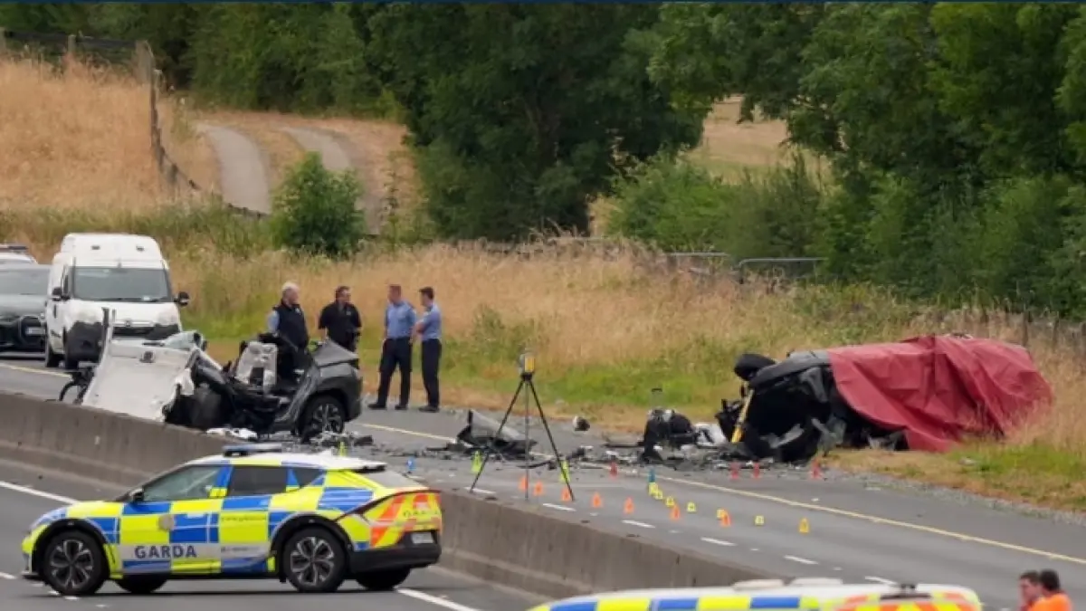 Petugas Garda Síochána mengamankan lokasi kecelakaan di sebuah jalan raya di Irlandia. Sejumlah kendaraan tampak mengalami kerusakan parah setelah tabrakan. (The Guardian)