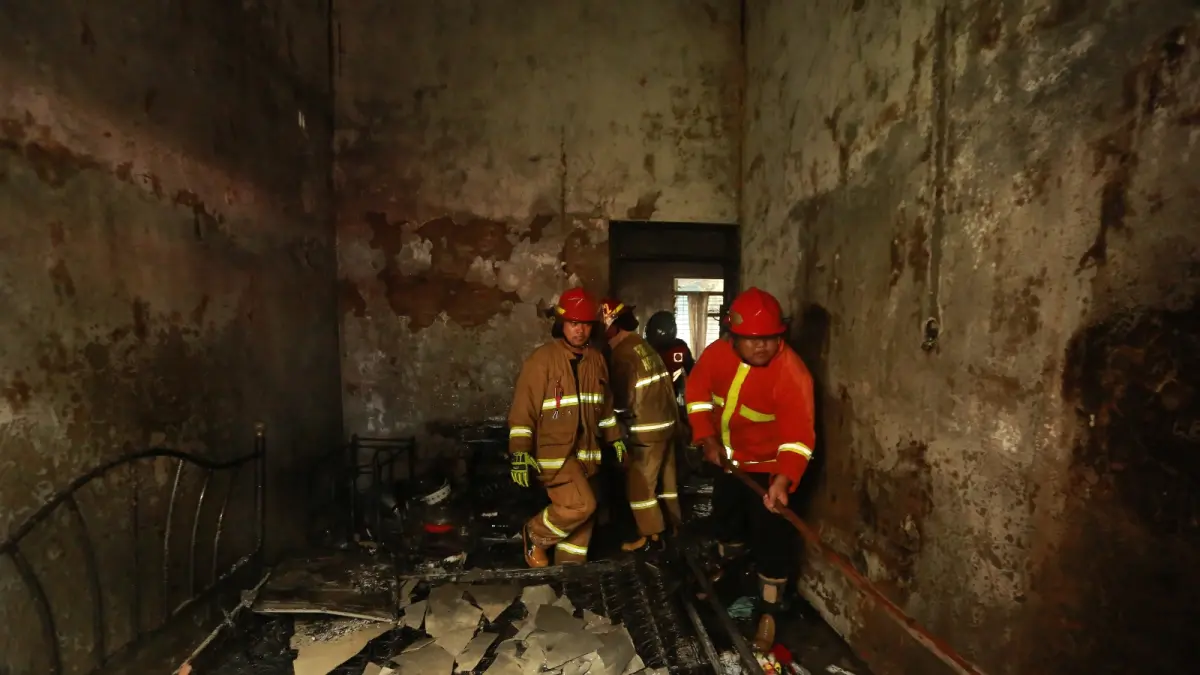 SEMPROT: Petugas Damkar Kota Madiun melakukan pemadaman dan pendinginan rumah yang terbakar di Jalan Slamet Riyadi, Kelurahan Klegen, Kamis (20/8). BAGAS BIMANTARA/JAWA POS RADAR MADIUN