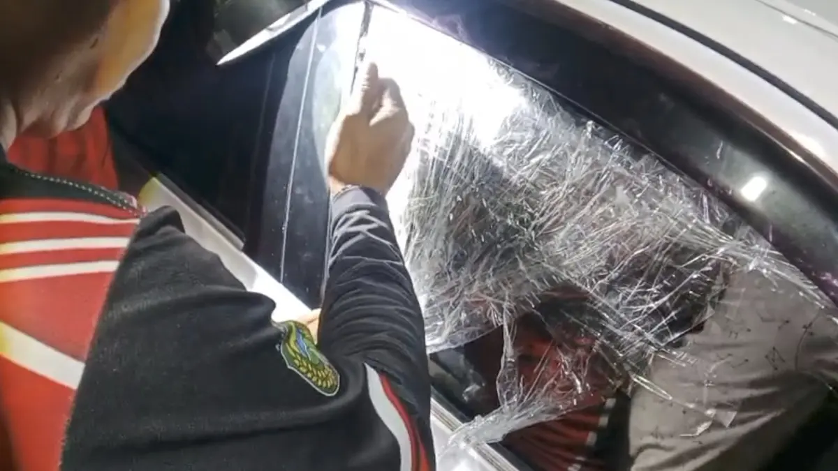 BERHASIL DIEVAKUASI: Petugas Damkar Kota Madiun membuka pintu mobil untuk menyelamatkan seorang anak yang terkunci di dalam kendaraan di Nambangan Kidul. FOTO: DAMKAR KOTA MADIUN