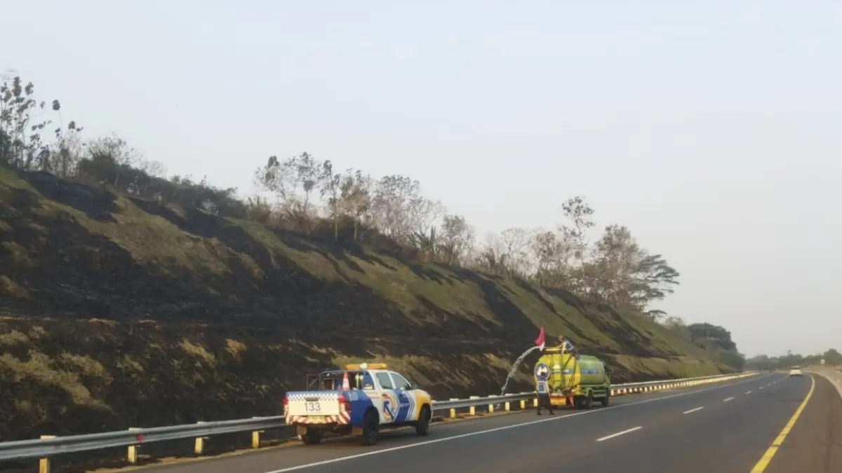 SIGAP: Petugas PT JNK memadamkan kebakaran rumput di tebing KM 630 A Tol Ngawi–Kertosono, Minggu (23/8).