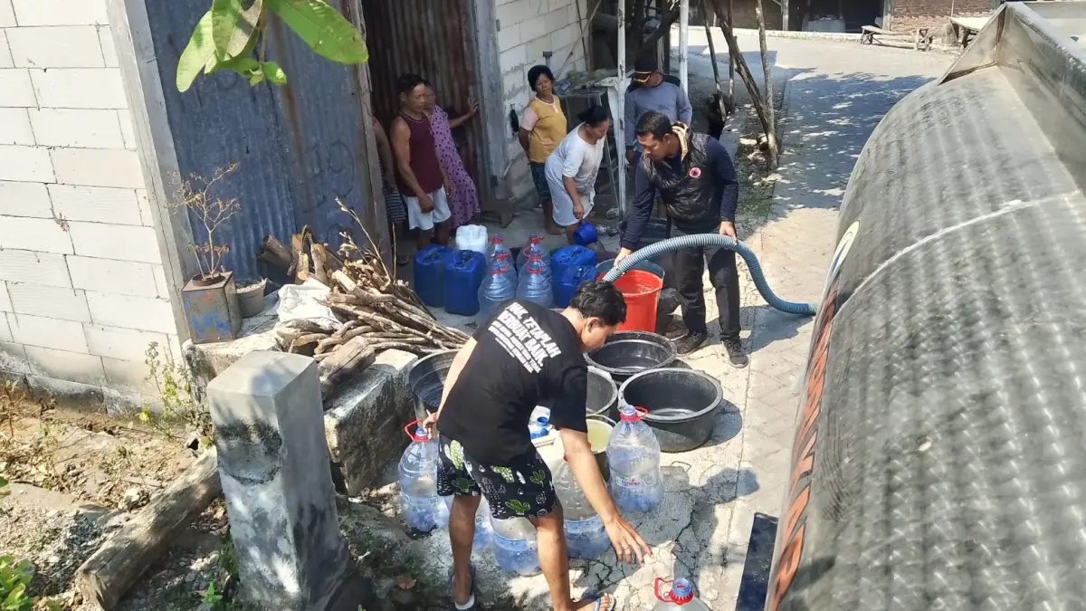DARURAT AIR: Petugas menyalurkan air bersih kepada warga terdampak kekeringan. Krisis air bersih di Ngawi kini meluas ke 12 desa di lima kecamatan dengan 1.627 jiwa terdampak. ASEP SYAEFUL/RADAR NGAWI
