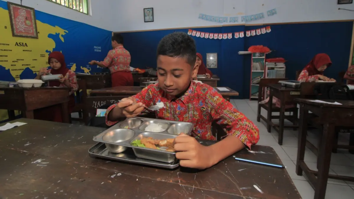 PROGRAM PRIORITAS: Siswa salah satu sekolah di Magetan menyantap menu Makan Bergizi Gratis di dalam kelas. Aji Putra/Radar Magetan