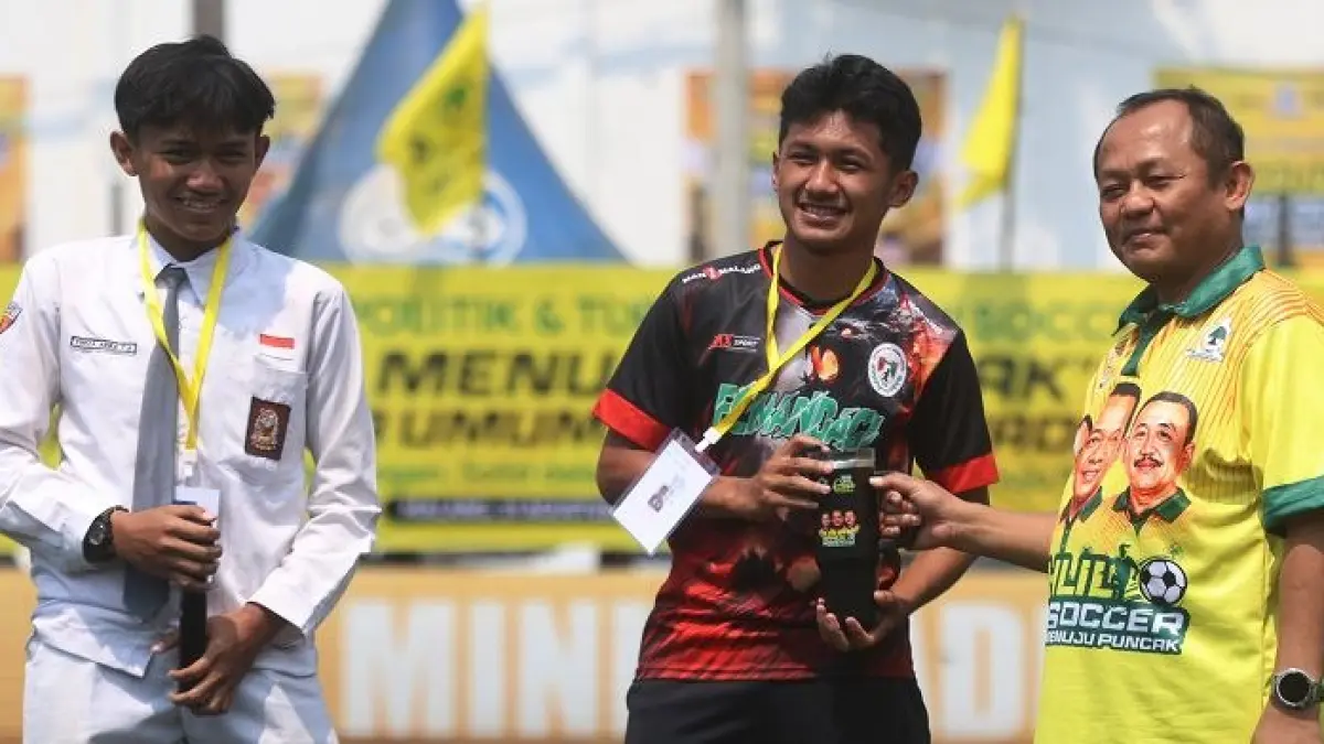 Sekjen DPP Partai Golkar Sarmuji (kanan) memberikan hadiah kepada peserta turnamen yang berhasil menjawab kuis di pembukaan zona Malang, Senin (31/8).