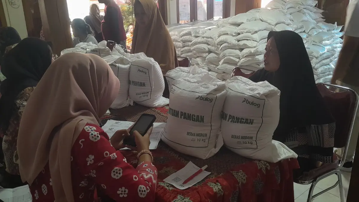 BANTUAN PANGAN: Warga mengambil bantuan pangan beras dari pemerintah pusat di Kantor Kelurahan Ketanggi, Ngawi, Senin (31/8). 