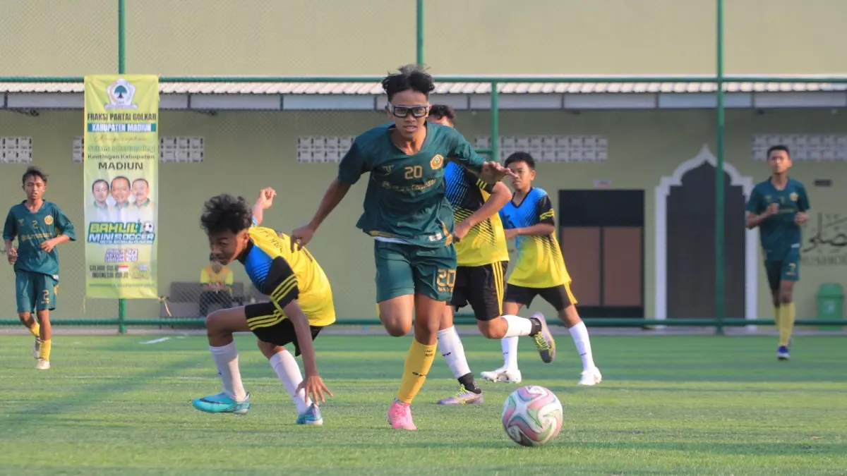 Pemain MAN 2 Kota Madiun Sakha menggiring bola menghindari kejaran pemain SMKN 3 Pacitan dalam penyisihan Bahlil Mini Soccer Zona Madiun Raya, Kamis (3/9). (AJI PUTRA/RADAR MADIUN)