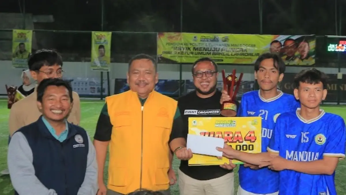 Direktur Jawa Pos Radar Madiun Ockta Prana Lagawira (tiga dari kanan) didampingi Ketua DPD Partai Golkar Jawa Timur Ali Mufthi (empat dari kanan) menyerahkan hadiah kepada MAN 2 Ponorogo yang meraih gelar juara empat Bahlil Mini Soccer Zona Madiun Raya, Jumat (4/9). (BAGAS BIMANTARA/RADAR MADIUN)