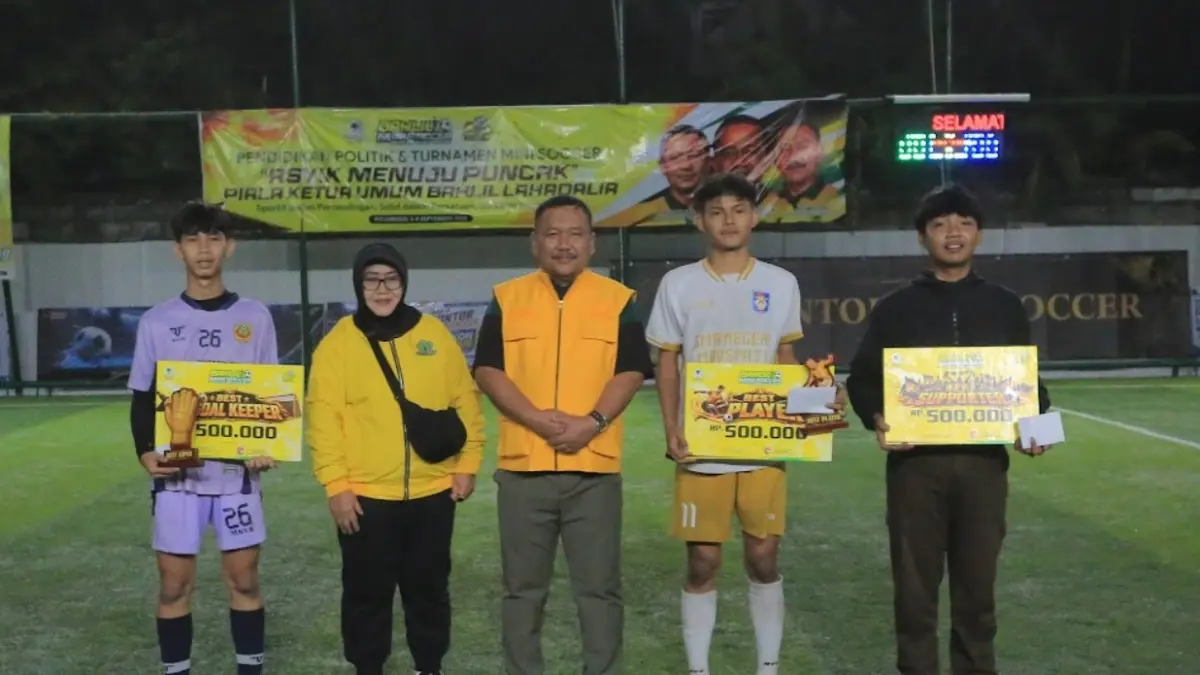 Ketua DPD Partai Golkar Jawa Timur Ali Mufthi (rompi oranye) didampingi Anggota Fraksi Golkar DPRD Jawa Timur Atika Banowati (jaket kuning) menyerahkan hadiah kepada best player, best goalkeeper, dan best supporter dalam ajang Bahlil Mini Soccer Zona Madiun Raya, Jumat (4/9). (BAGAS BIMANTARA/RADAR MADIUN)
