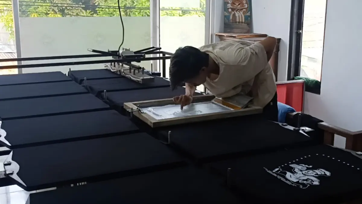 TEKUN: Adi Baskoro mempertahankan sablon manual di tengah berkembangnya teknologi cetak digital. Silva Yudia Azizah/Magang/Jawa Pos Radar Ngawi