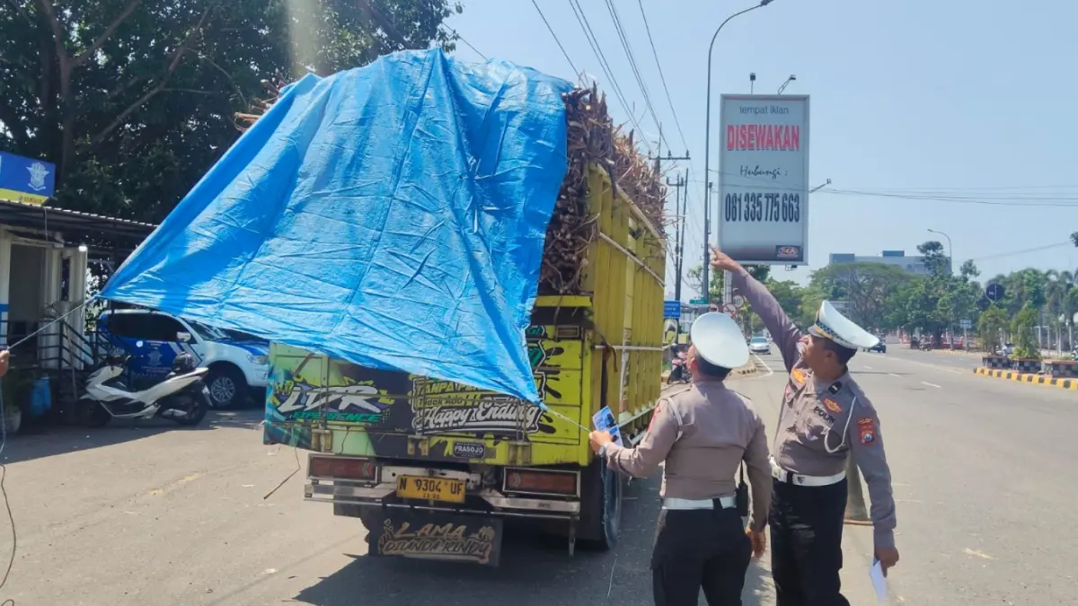 DIIMBAU: Petugas Satlantas Polres Ngawi menghentikan truk tebu saat penertiban di Jalan Ngawi-Solo, Desa Grudo, Kecamatan Ngawi, Senin (7/9). Polres Ngawi untuk Jawa Pos Radar Ngawi