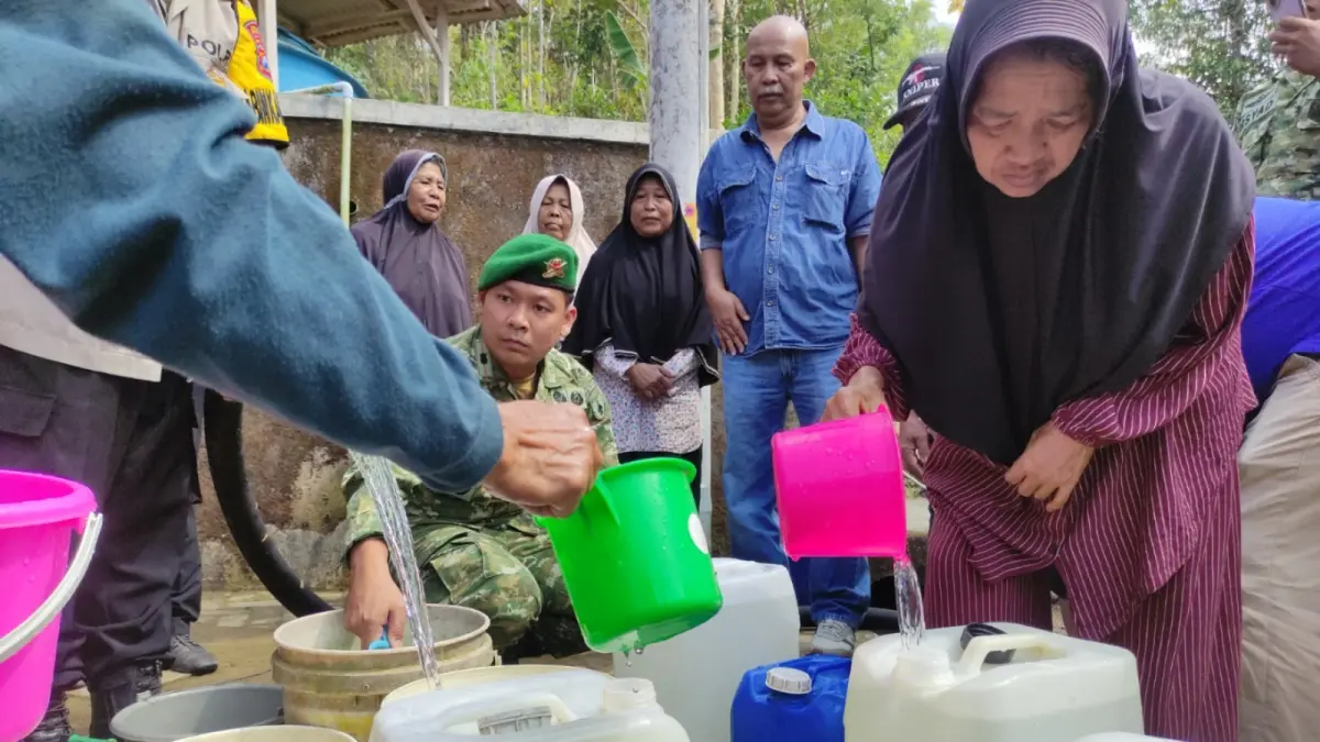 ANTRE AIR: Warga Dusun Klisat, Desa Tambakrejo, Kecamatan Pacitan, membawa jeriken untuk menampung dropping air bersih, Jumat (11/9). Nur Cahyono/Jawa Pos Radar Pacitan