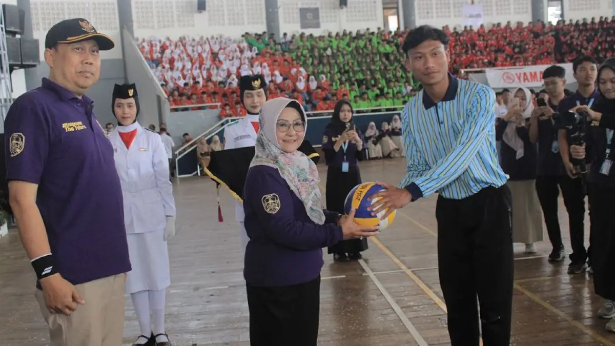 Bupati Magetan Endang Nanik Rusminiarti menyerahkan bola voli tanda dimulainya Smasa Bupati Cup XVII, Senin (14/9).