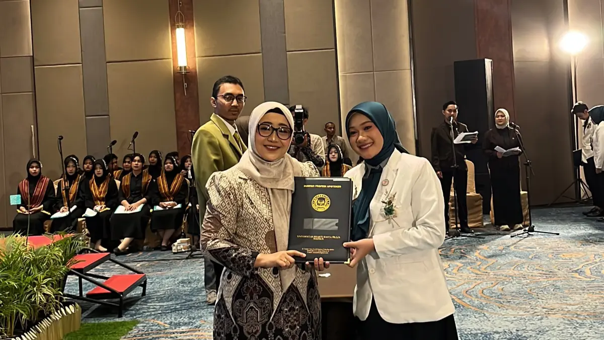 Rektor UBHM Madiun Retno Widiarini menyerahkan SK Profesi NERS kepada wisudawati jurusan apoteker.