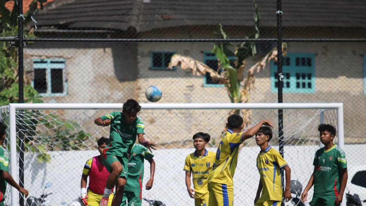 KETAT: Pemain MAN 2 Pamekasan (jersey hijau) menghalau bola atas saat mendapat serangan dari pemain-pemain SMAN 4 Pamekasan di Turnamen Bahlil Mini Soccer Asyik Menuju Puncak Zona 8 Madura di Puri Dewata Mini Soccer Pamekasan. (FAHMI JALIL/RADAR MADURA)