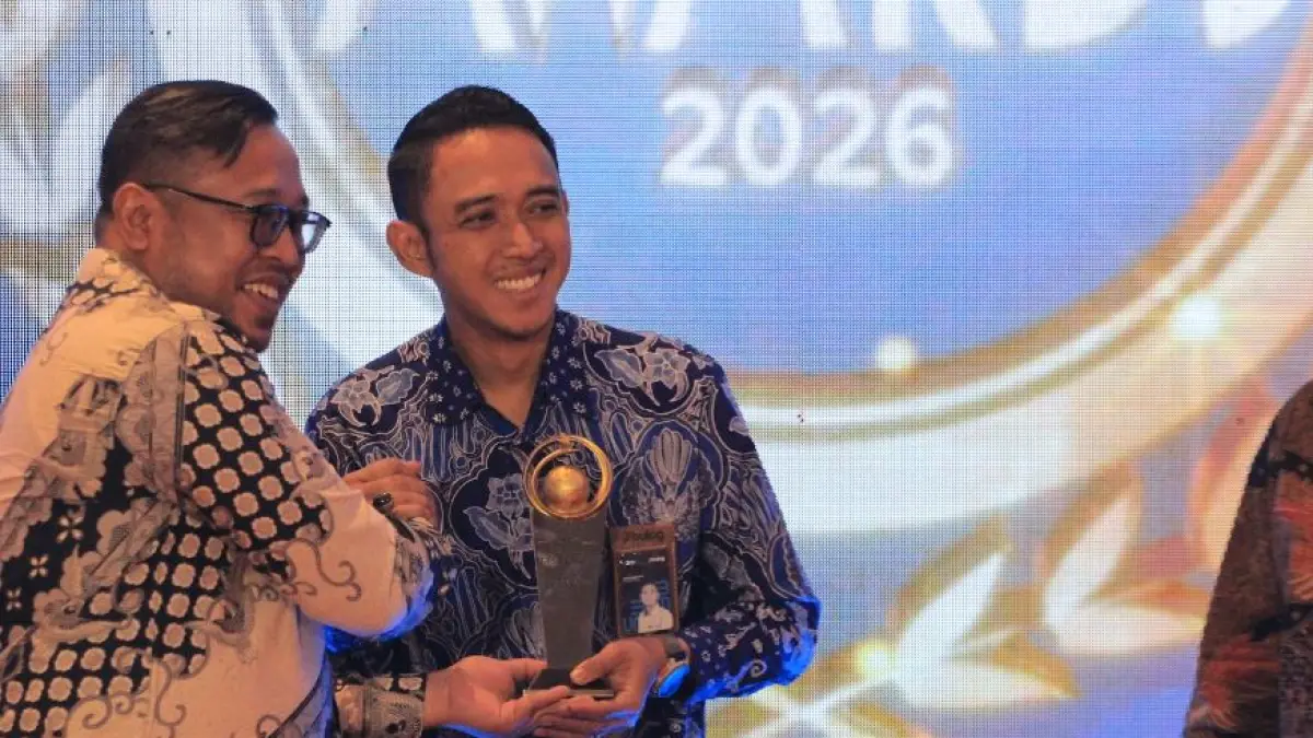 Pemimpin Cabang Perum Bulog Madiun Agung Sarianto menerima penghargaan Best BUMN Radar Madiun Awards 2026 dari Direktur Jawa Pos Radar Madiun Ockta Prana. (BAGAS BIMANTARA/RADAR MADIUN)