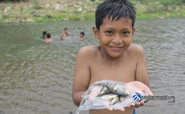 JANGAN DIKOTORI: Danis Rahmat, menunjukkan hasil tangkapan ikannya dengan tangan kosong dari Sungai Grindulu yang mengalir di Dusun Banyuanget, Kedungbendo, Arjosari, Jumat (15/11).
