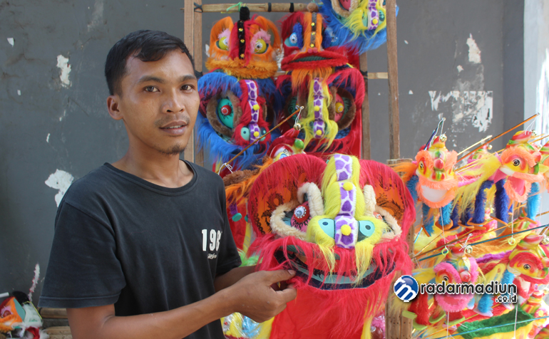 REPLIKA: Warnita menunjukkan mainan barongsai yang dijualnya di dekat lokasi Peceland Chinese New Year Festival.
