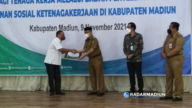 SIMBOLIS: Wakil Bupati Hari Wuryanto didampingi Kepala BPJS Ketenagakerjaan Cabang Madiun Honggy Dwinanda Hariawan dan Kepala Disnaker Heru Kuncoro menyerahkan penghargaan kepada sejumlah perusahaan yang turut mendukung program jaminan sosial tenaga kerja
