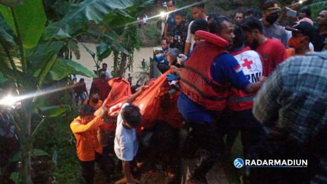 EVAKUASI: Petugas SAR dibantu dengan warga mengevakuasi jasad Alfian Yusuf yang ditemukan sudah tak bernyawa ketika terseret arus Kali Catur, Sabtu (20/11). BAGAS BIMANTARA/RADAR MADIUN