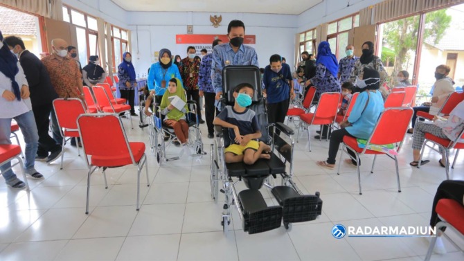 PEDULI: Wali Kota Maidi saat menyerahkan bantuan kepada anak korban Covid-19 dan penyandang disabilitas. (BAGAS BIMANTARA/JAWA POS RADAR MADIUN)