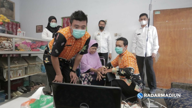 JEMPUT BOLA: Petugas Disdukcapil Kota Madiun mendatangi rumah warga lansia untuk melakukan perekaman e-KTP. (BAGAS BIMANTARA/JAWA POS RADAR MADIUN)