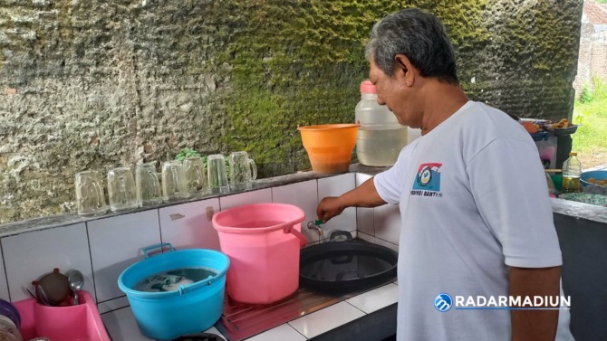 MAMPET: Salah seorang pedagang NSF menunjukkan keran yang tidak keluar airnya. (ASEP SYAEFUL BACHRI/JAWA POS RADAR NGAWI)