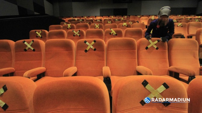 RAPI: Petugas ketika merapikan kursi atau tempat duduk di bioskop.