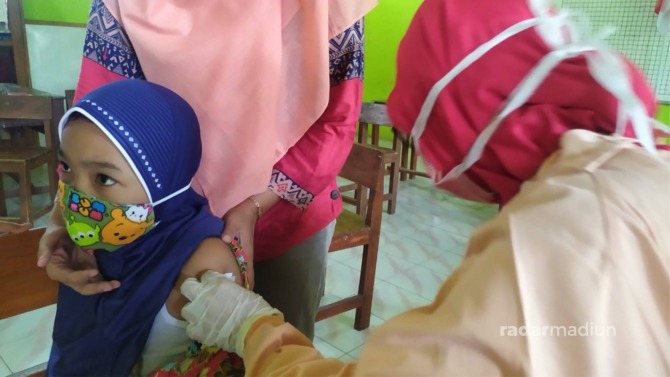 HERD IMMUNITY: Seorang anak menjalani vaksinasi di Dagangan kemarin. (ANGGIYAN BAYU/RADAR MADIUN)