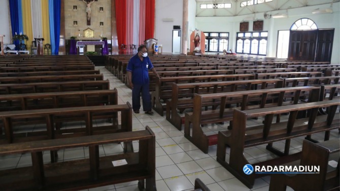 HYBRID: Pengurus Gereja Mater Dei mengecek tempat ibadah sebagai persiapan misa Natal yang akan digelar secara hybrid tahun ini. (BAGAS BIMANTARA/JAWA POS RADAR MADIUN)