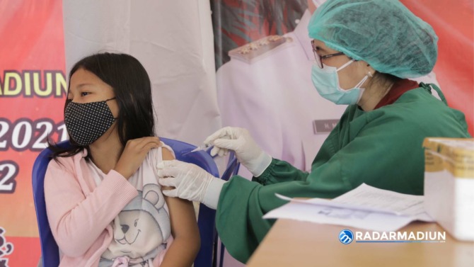 PERLINDUNGAN: Anak usia 6-11 tahun asli Kota Madiun dapat mengakses layanan vaksinasi di Sumber Wangi didampingi orang tua. (BAGAS BIMANTARA/JAWA POS RADAR MADIUN)