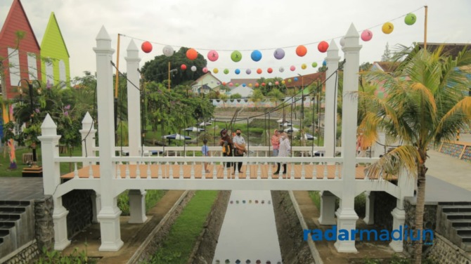 WARNA-WARNI: Di sebelah barat jembatan bakal dibangun miniatur Menara Eiffel. Pengembangan kawasan Sumber Umis tuntas tahun ini.  (BAGAS BIMANTARA/JAWA POS RADAR MADIUN )