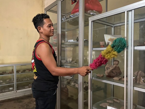 BERSEJARAH: Masruri di depan etalase kaca tempat penyimpanan artefak. (M.R. AKROMU NIAM/JAWA POS RADAR CARUBAN)