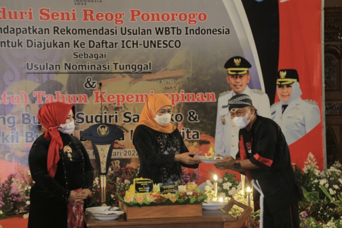 PONOROGO HEBAT: Gubernur Jatim Khofifah Indar Parawansa memberikan potongan tumpeng kepada Bupati Sugiri Sancoko sebagai penanda satu tahun kerja kepala daerah tersebut bersama wakilnya. (BAGAS BIMANTARA/RADAR MADIUN)