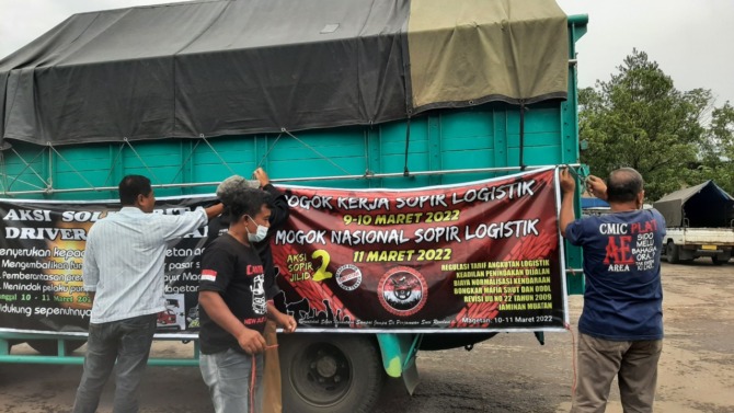 DEMI TIGA TUNTUTAN: Sejumlah sopir membentangkan spanduk protes di bak truk saat menyampaikan aspirasi di Pasar Sayur kemarin (10/3). (MAULANA RAIHAN/JAWA POS RADAR MAGETAN)