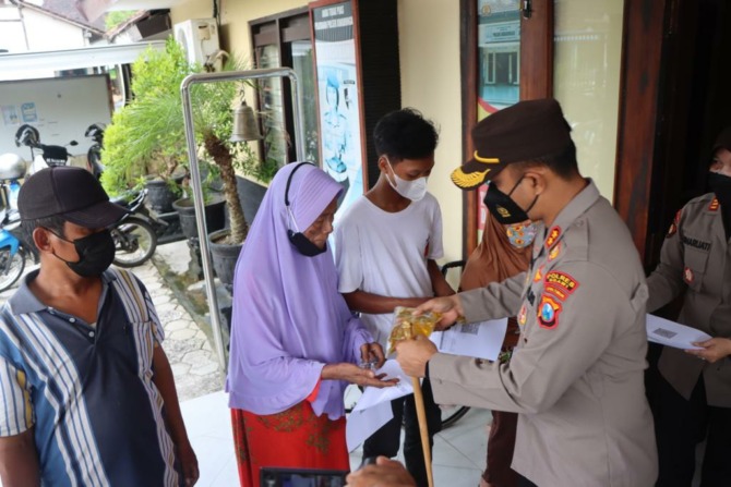 CARA UNIK: Peserta vaksinasi Covid-19 di Polsek Kwadungan mendapatkan minyak goreng gratis. (ASEP SYAEFUL BACHRI/JAWA POS RADAR NGAWI)