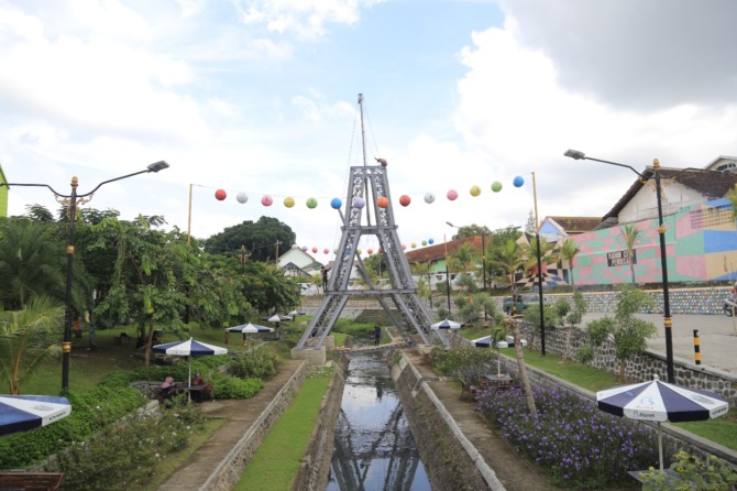SETENGAH JADI: Pembangunan replika Menara Eiffel di kawasan Sumber Umis dalam pengerjaan, Selasa (15/3). Bangunan itu akan melengkapi rumah replika Tudor, Kakbah, dan London Bridge. (BAGAS BIMANTARA/JAWA POS RADAR MADIUN)